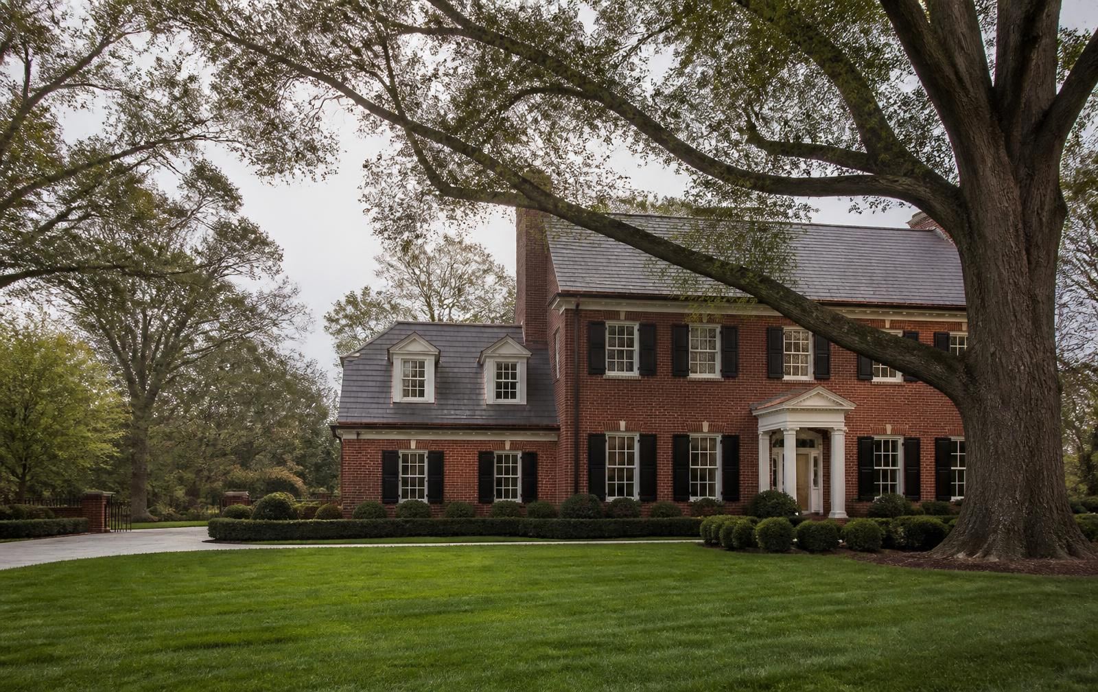Red-brick Georgian estate home beneath mature willow oaks in SouthPark, Charlotte