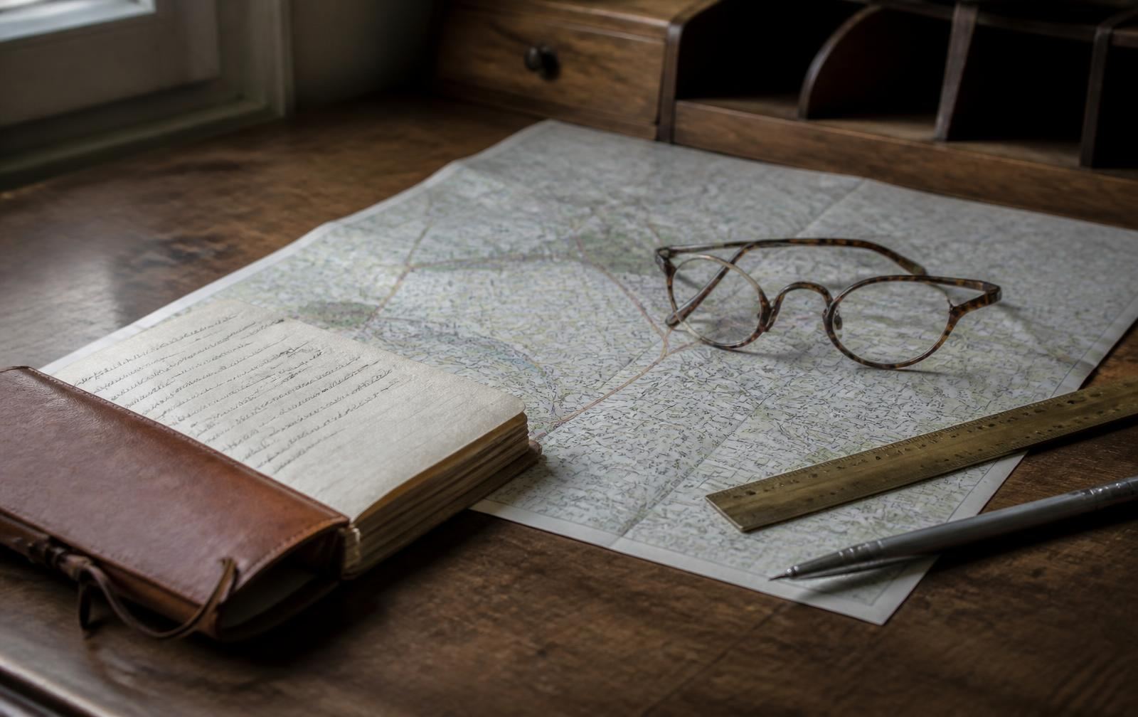 Desk with a printed street map, ruler and notebook used to measure school distances